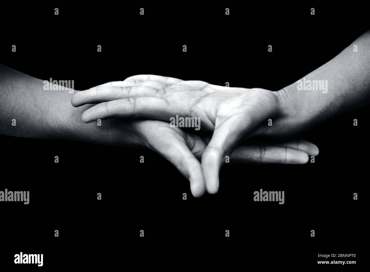 Primo piano di mani maschili che dimostrano Buddha Mudra su sfondo nero. Foto Stock