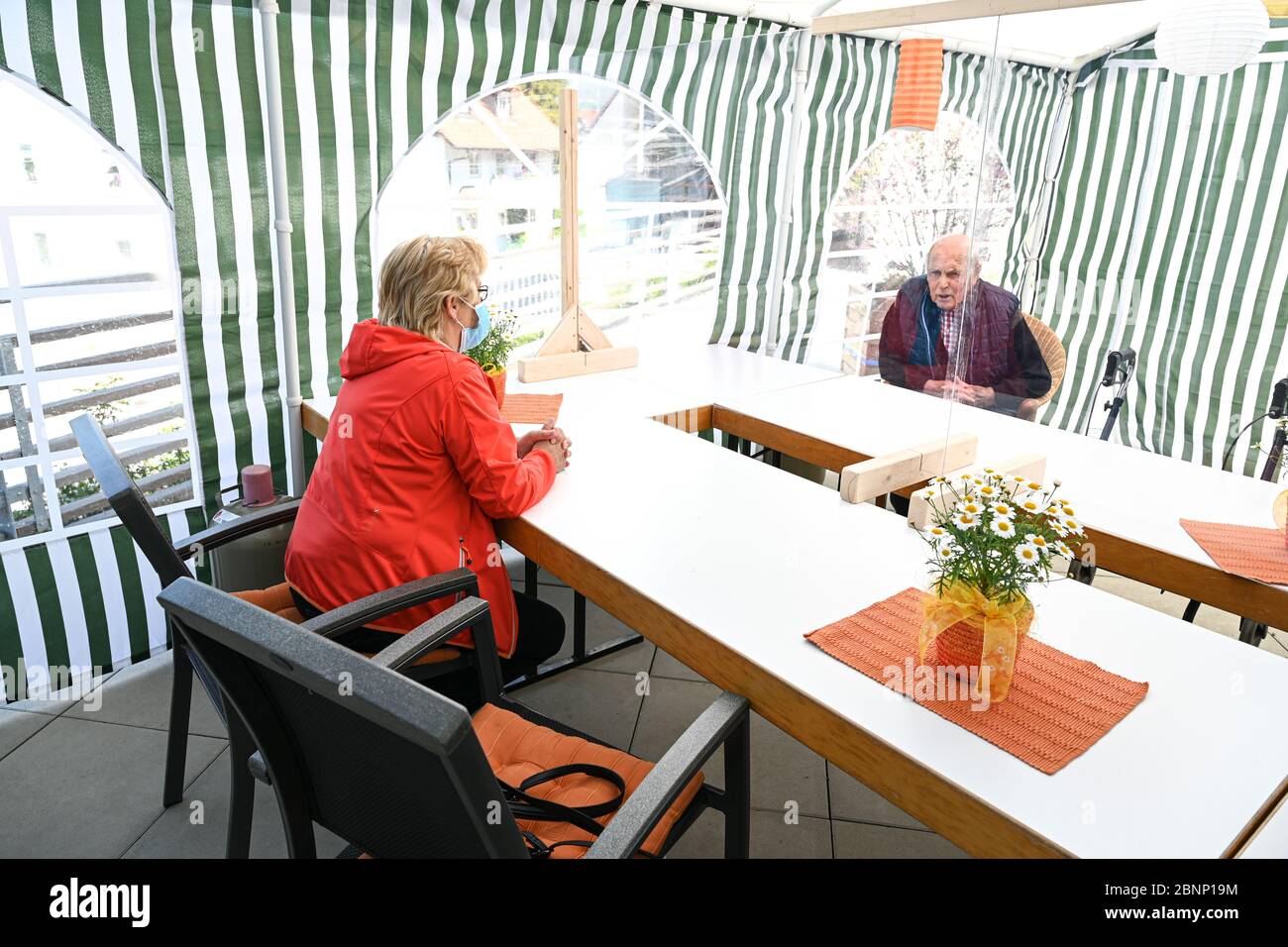 06 maggio 2020, Baden-Wuerttemberg, Isny im Allgäu: Residente Josef Brauchle (r) e sua nipote Angela EPP che parlano nella tenda di visita del centro di assistenza per anziani di Isny. I due sono separati da un pannello in plexiglass. (A dpa: 'Chattando dietro Plexiglas: Case di cura relax visita divieto') Foto: Felix Kästle/dpa Foto Stock