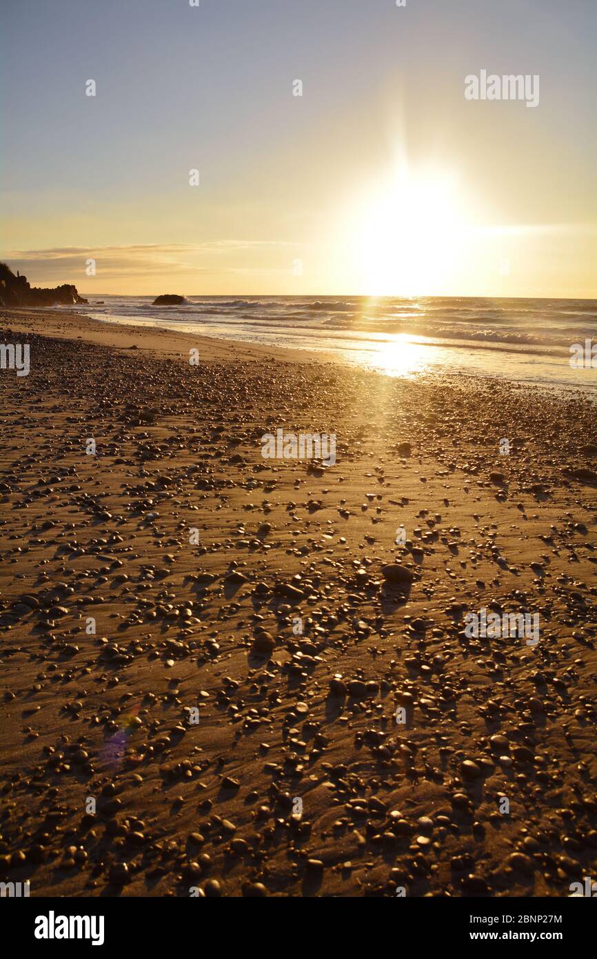 Tramonto con colori caldi sulla spiaggia di Granity, Nuova Zelanda Foto Stock