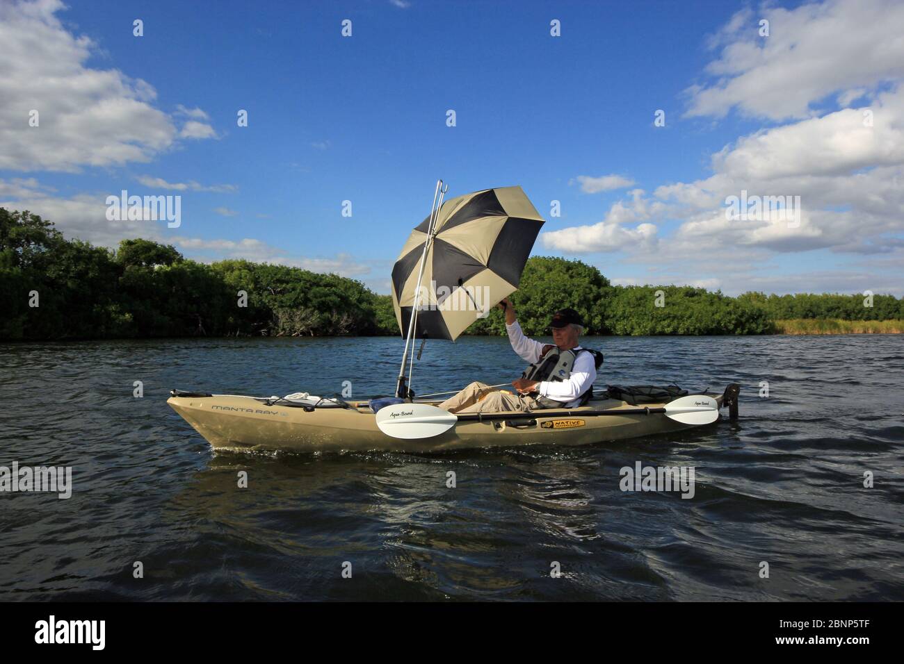 Senior attivo usando un ombrello come una vela mentre il kayak in Biscayne  Bay off il punto nero, a sud di Miami, Florida Foto stock - Alamy