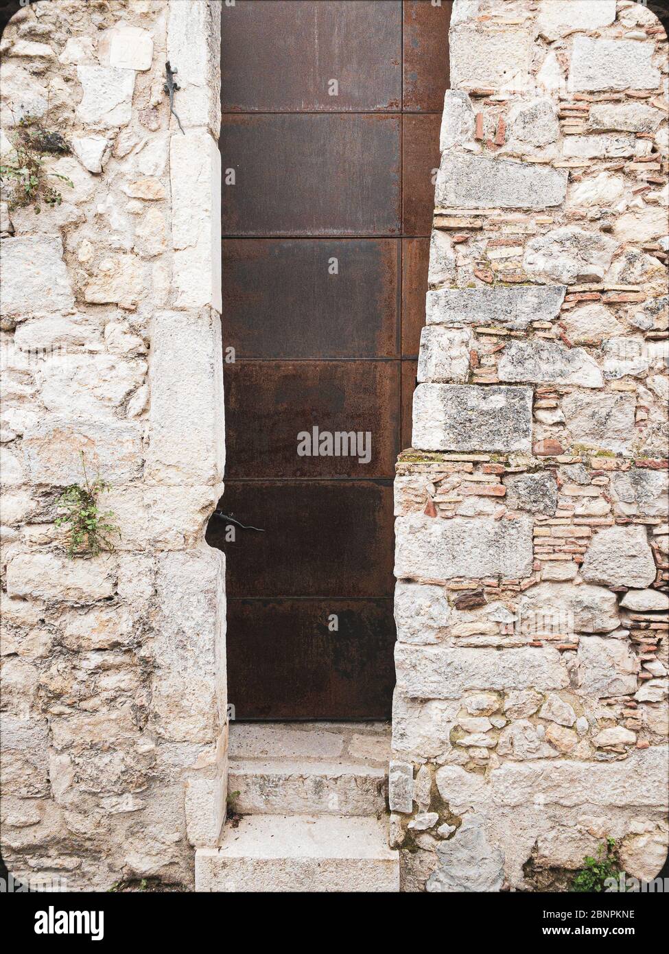 Particolare di una porta moderna incastonata in un muro medievale situato nel centro storico di Girona in Catalogna Spagna Foto Stock