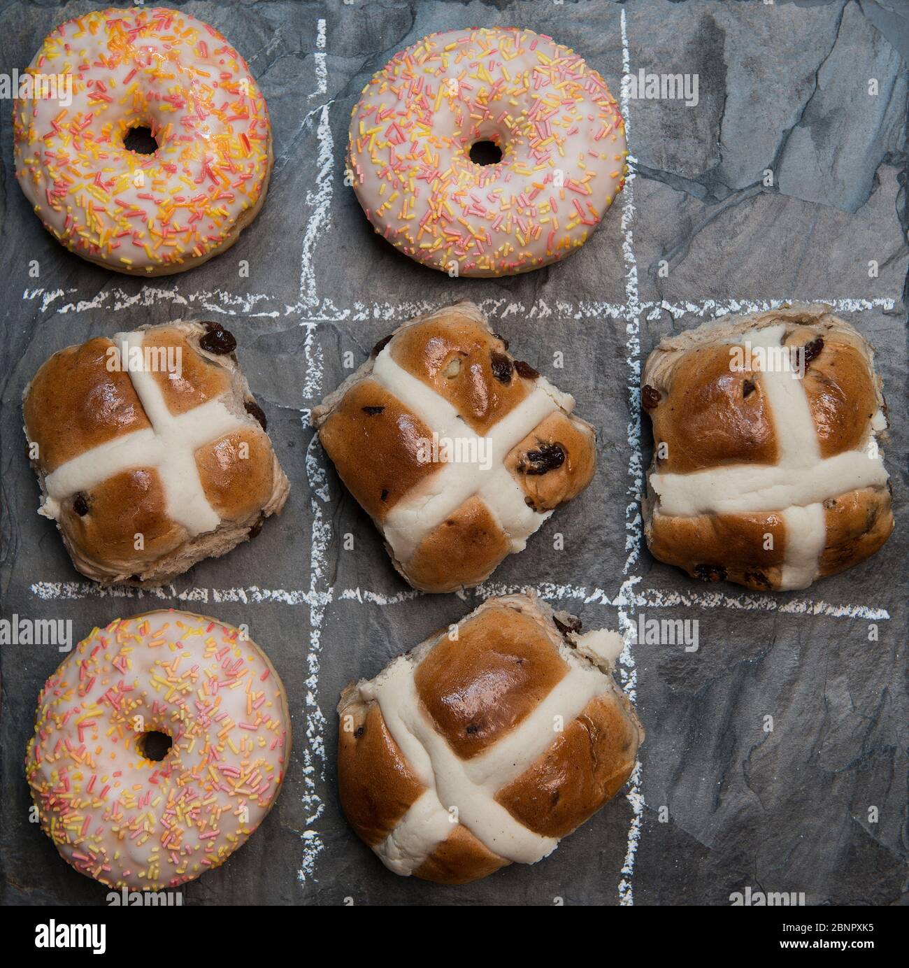 Giocando noughts e croci con ciambelle e focacce di croce calda, una di sequenza di immagini Foto Stock