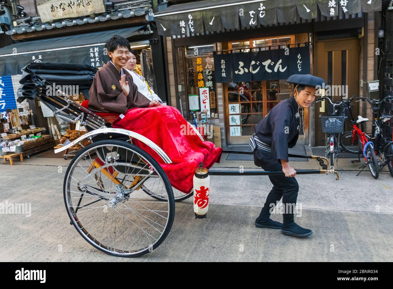 Giappone, Honshu, Tokyo Asakusa, giovane di equitazione in Rickshaw Foto Stock