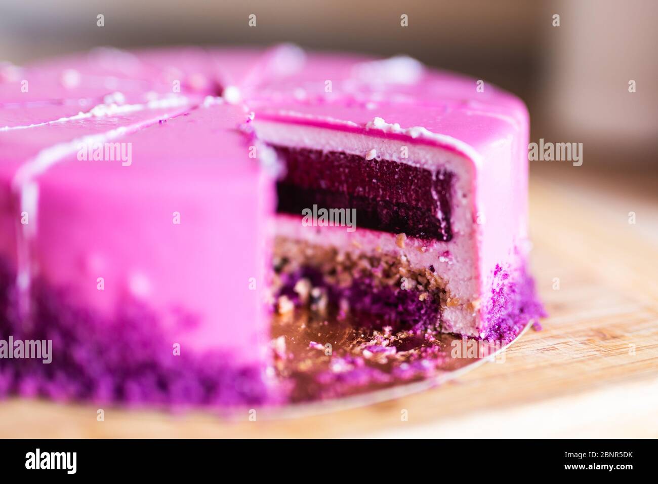 Torta di compleanno rosa e viola senza un pezzo. Dessert, vacanze e delizioso concetto. Foto Stock