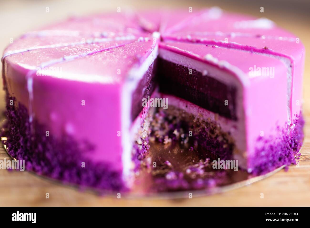 Torta di compleanno rosa e viola senza un pezzo. Dessert, vacanze e delizioso concetto. Foto Stock