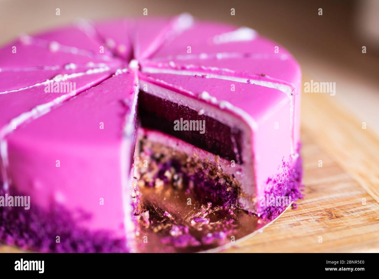 Torta di compleanno rosa e viola senza un pezzo. Dessert, vacanze e delizioso concetto. Foto Stock