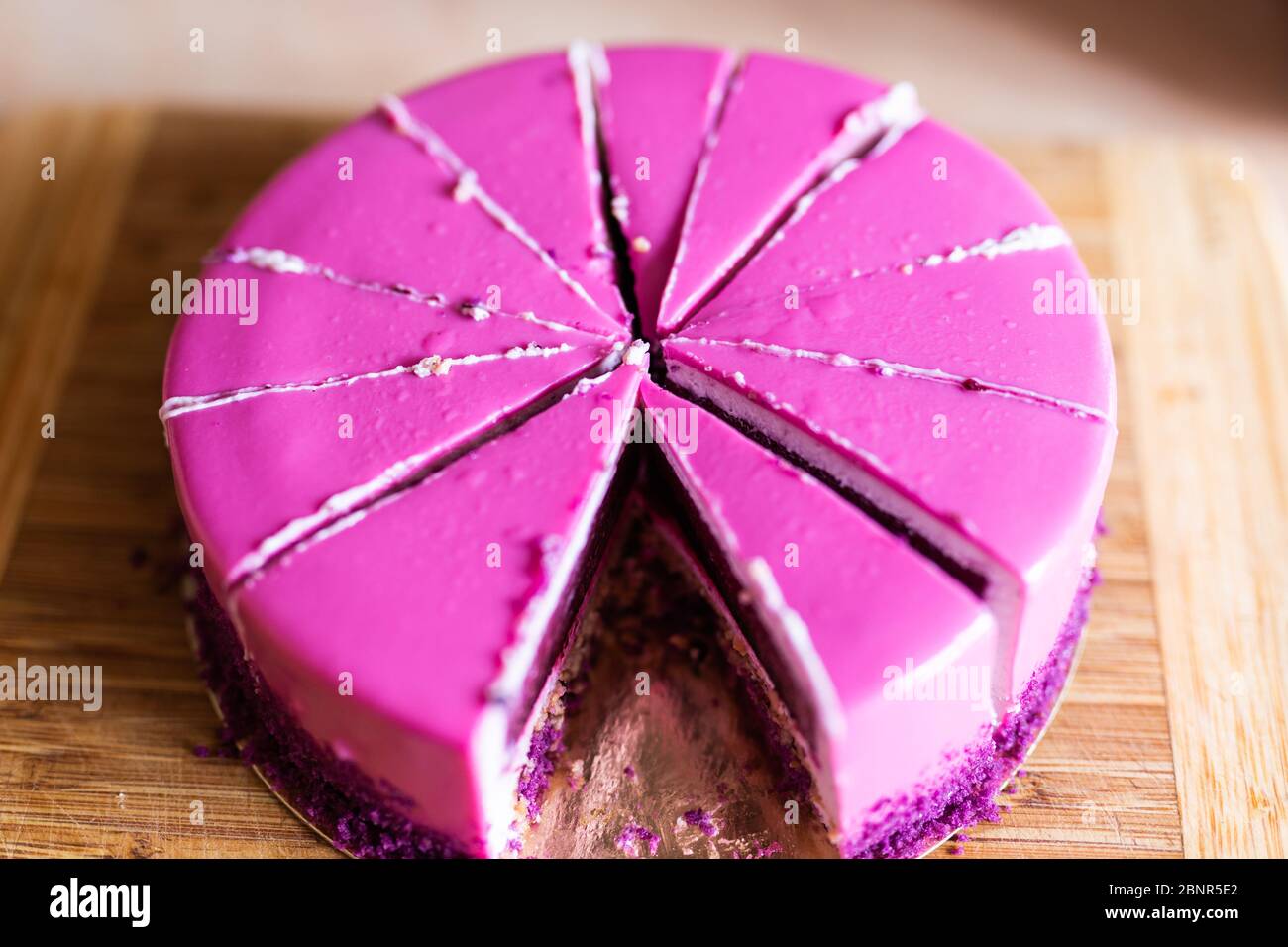Torta di compleanno rosa e viola senza un pezzo. Dessert, vacanze e delizioso concetto. Foto Stock