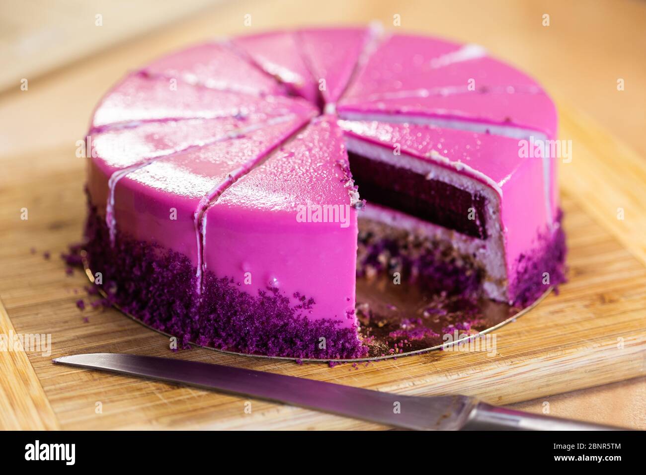 Torta di compleanno rosa e viola senza un pezzo. Dessert, vacanze e delizioso concetto. Foto Stock