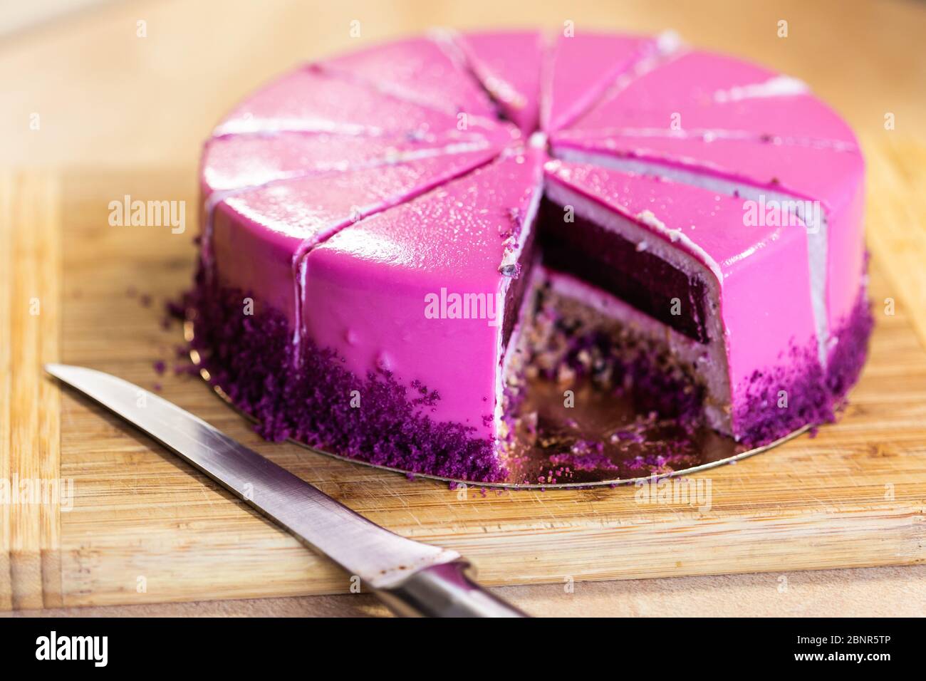 Torta di compleanno rosa e viola senza un pezzo. Dessert, vacanze e delizioso concetto. Foto Stock