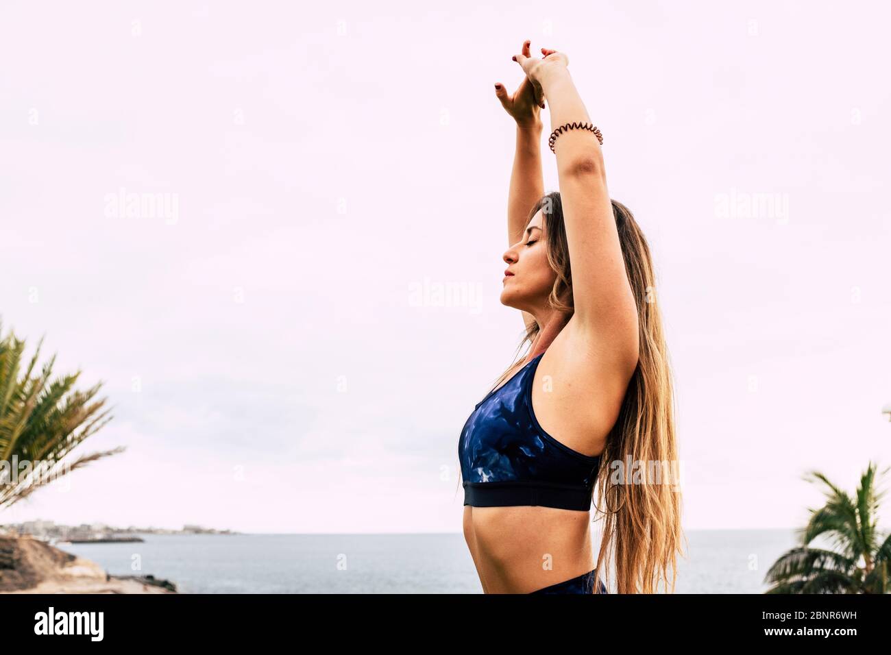 Beutiful giovane donna sana fare esercizi di stretching all'aperto godendo la natura - vista oceano sport persone attive - concetto di anima e meditazione per attività di benessere Foto Stock