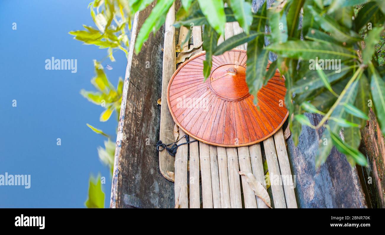 Myanmar Travel Images barca con pavimento di bambù e cappello coico in fuoco selettivo beyong verde foglie sfocate in acqua blu, Foto Stock