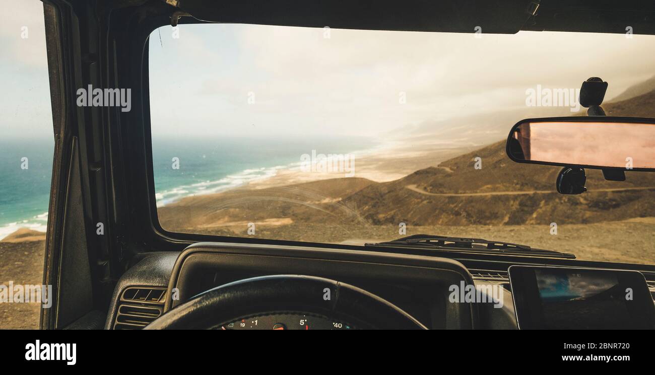 Vista interna dell'auto con cellulare moderno sistema gps per trovare la strada e utilizzare mappe in off Road luogo panoramico con vista sulla spiaggia e sulle montagne - concetto di avventura e roaming internet wifi ovunque Foto Stock