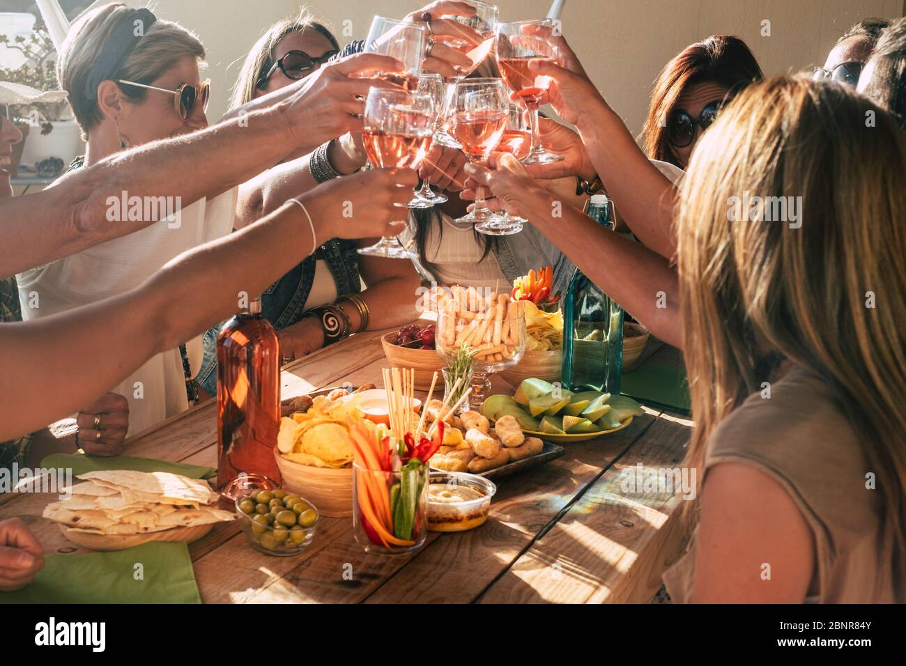 Gruppo di felici e allegri caucasici persone donne hanno divertimento tutti insieme bere e tostare con vino rosso - amicizia e festa concetto di celebrazione con le donne adulte Foto Stock
