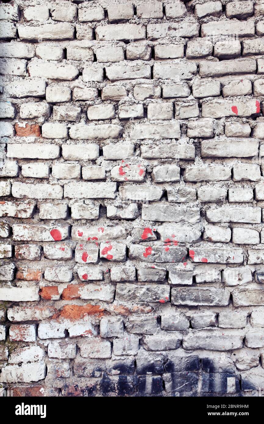 Parete di mattoni bianchi sporca con macchie di vernice per l'uso su sfondo o sfondo Foto Stock