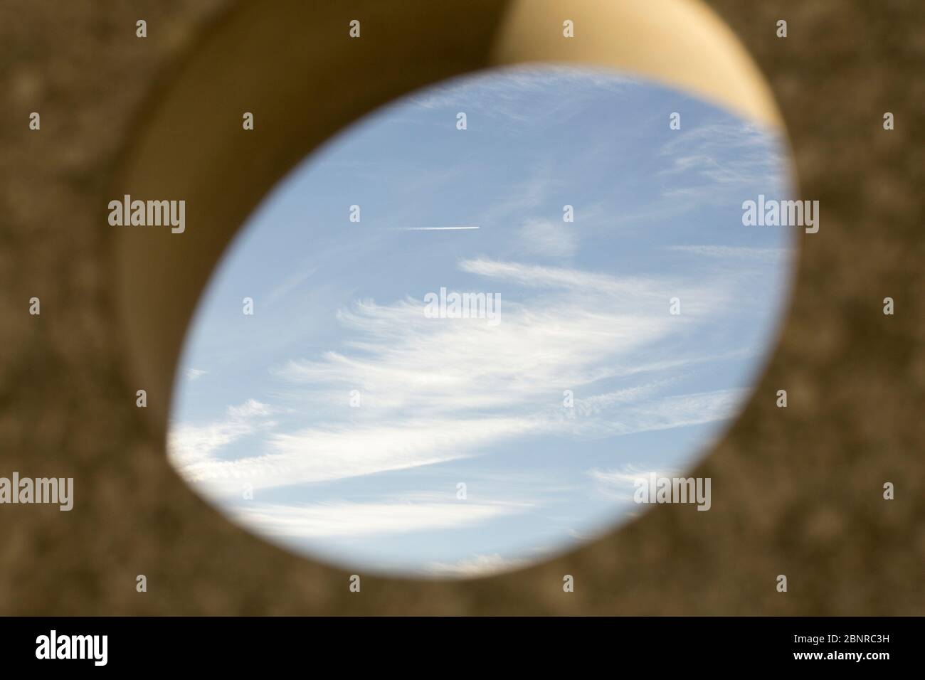 Contrails nel cielo fotografato attraverso un buco Foto Stock