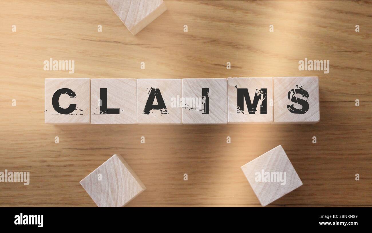 La parola di reclamo dai blocchi di legno sulla scrivania. Concetto di business assicurativo Foto Stock