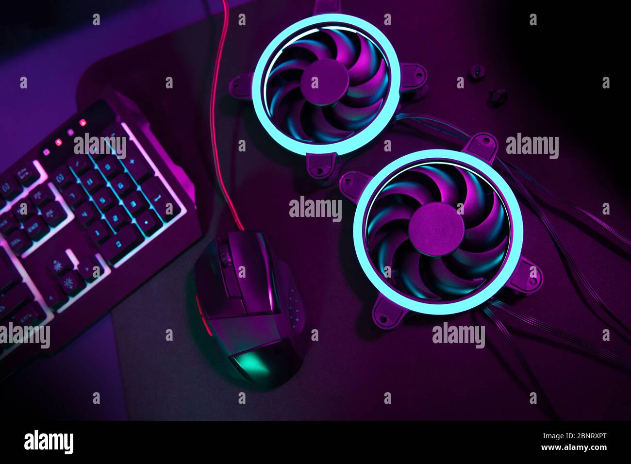 Moderno fan del computer con luce blu che si trova accanto al mouse per il gioco del computer e tastiera di gioco illuminata Foto Stock