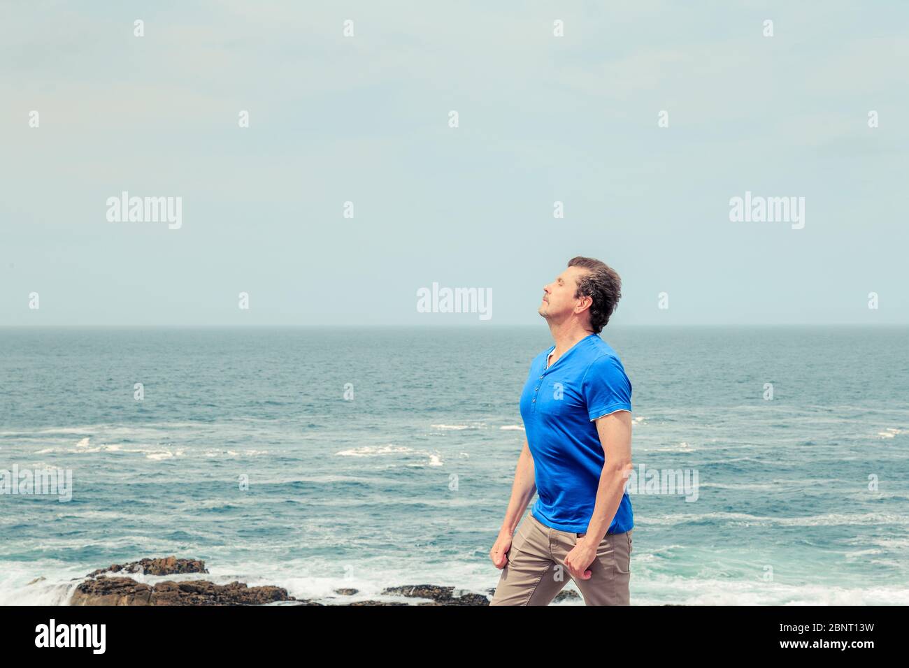 uomo con una sensazione di libertà al mare e respirando aria pura Foto Stock