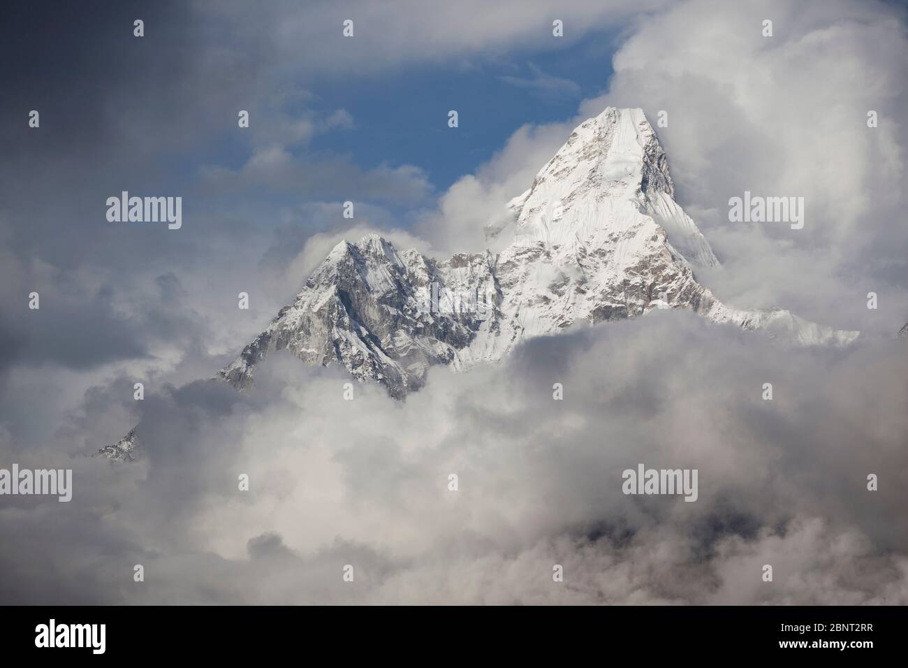 Monta Ama Dablam nelle nuvole tempeste. Catena montuosa dell'Himalaya. Nepal. Foto Stock