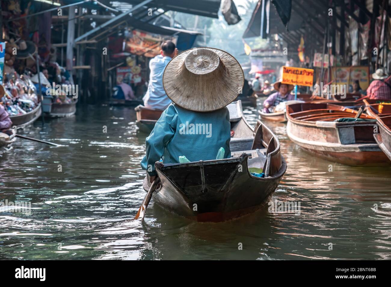 Ratchaburi, Damnoen Saduak / Thailandia - 11 febbraio 2020: Nome di questo luogo Damnoen Saduak mercato galleggiante. Vendor donna scull la barca con il suo cappello Foto Stock