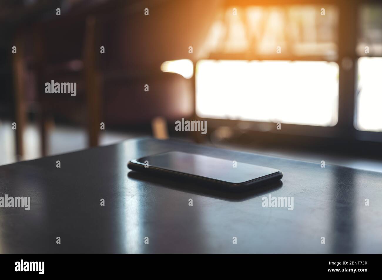 Un unico telefono cellulare nero sul tavolo Foto Stock