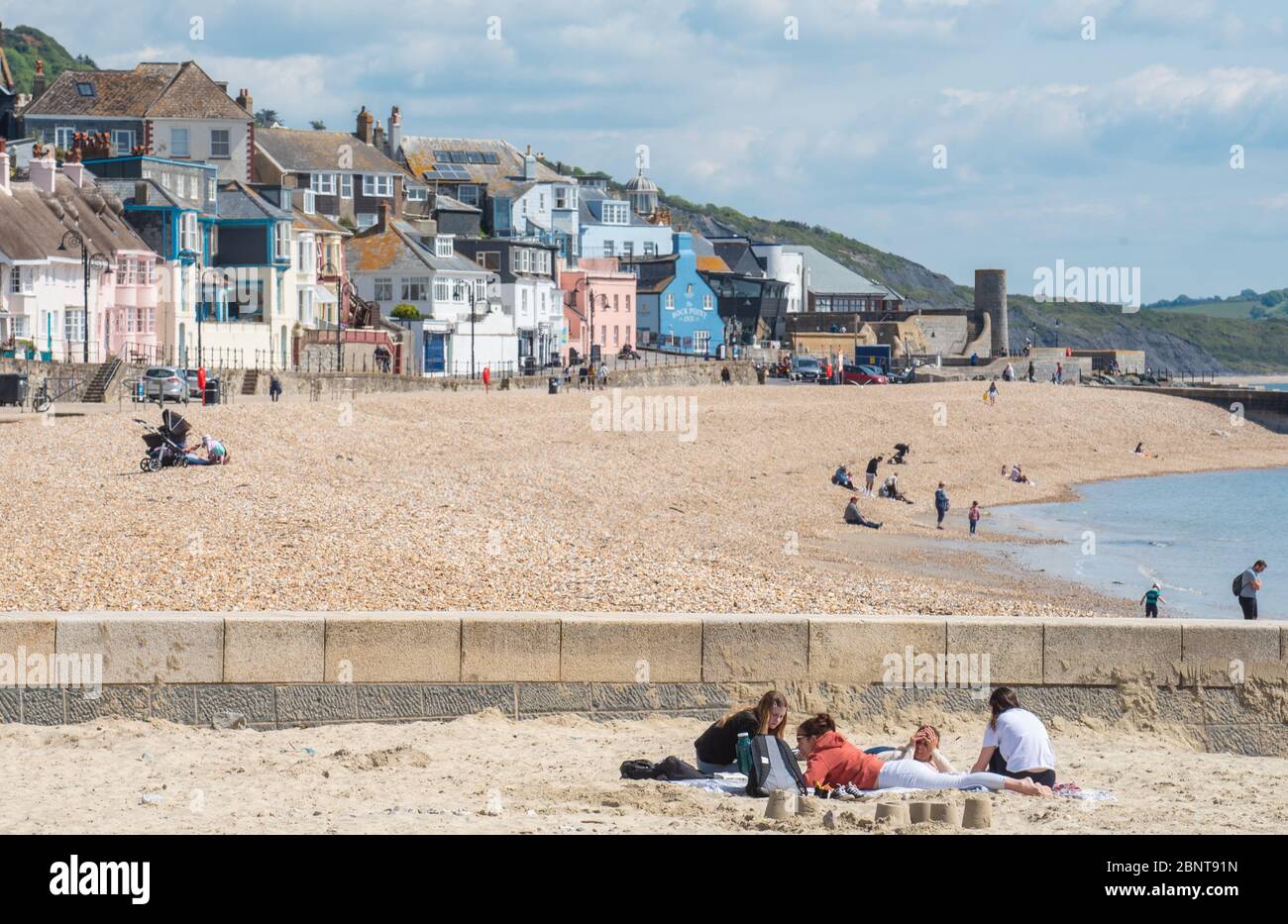 Lyme Regis, Dorset, Regno Unito. 16 maggio 2020. Regno Unito Meteo: La gente comincia a tornare alla spiaggia di Lyme Regis il primo Sabato soleggiato da quando le restrizioni del governo coronavirus sono stati attenuati. I visitatori provenienti da fuori Dorset sono invitati a 'stare lontano e visitare più tardi', come il consiglio ha gestito parcheggi e bagni pubblici presso le spiagge popolari e luoghi di bellezza in tutta la contea rimanere chiuso per scoraggiare le persone provenienti da fuori della regione di visitare su ciò che è impostato per essere un caldo e weekend soleggiato. Credit: Celia McMahon/Alamy Live News Foto Stock