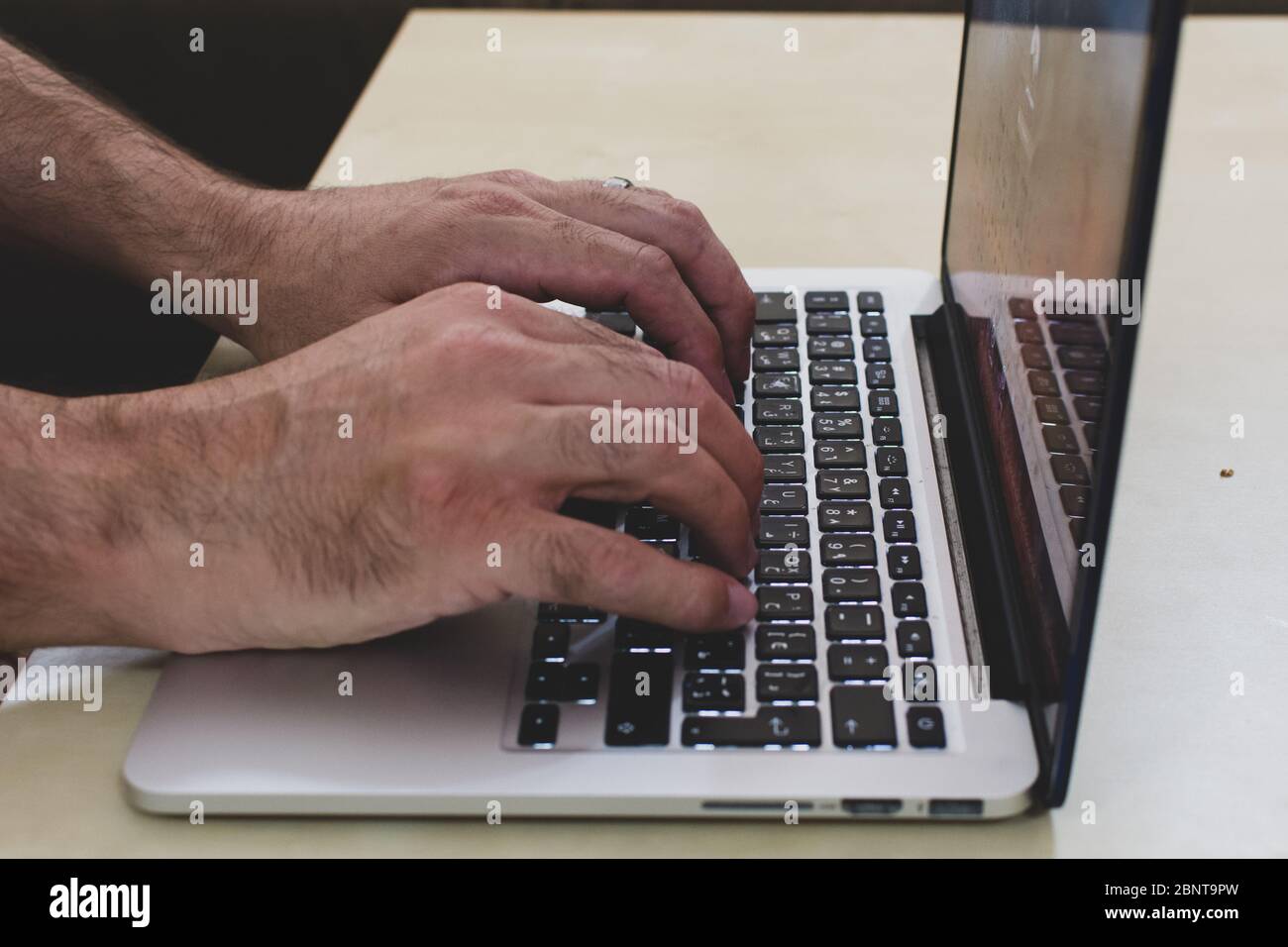 Lavorare da casa digitando le mani sul computer per i concetti di distanza sociale e COVID-19 (Coronavirus). Foto Stock
