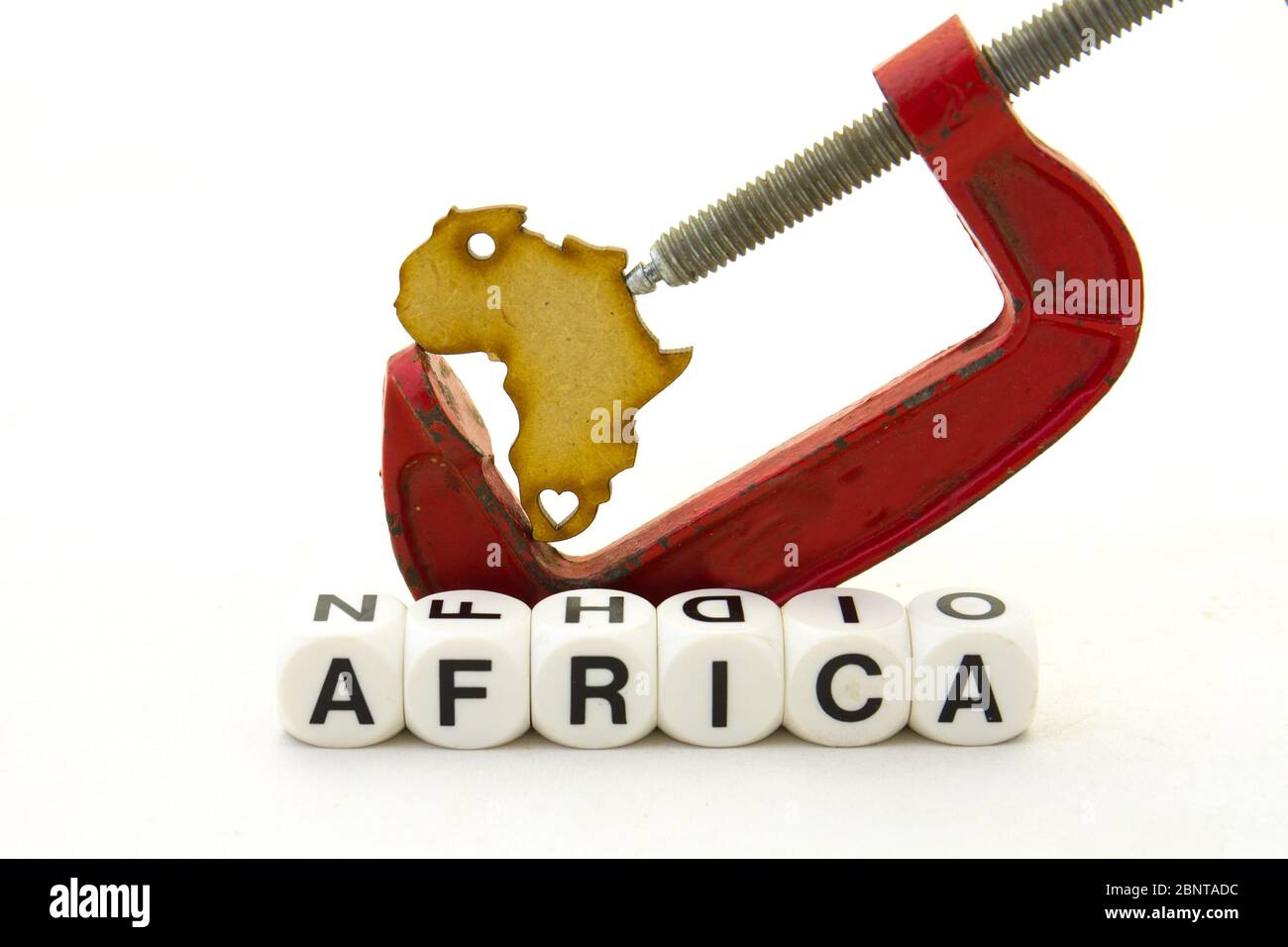 Una forma tagliata del continente africano stretta in un morsetto isolato su un'immagine di sfondo chiara con spazio di copia Foto Stock
