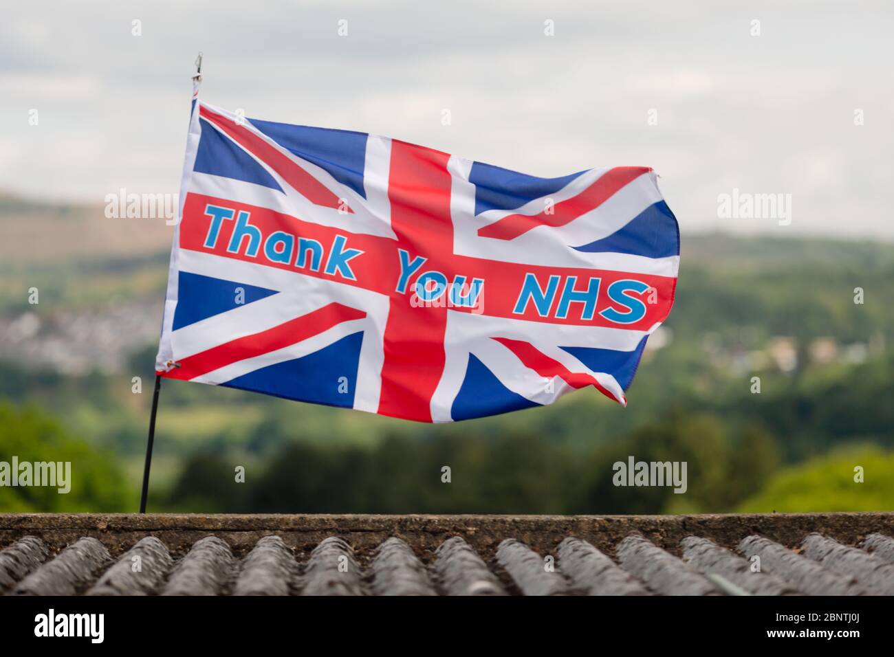 Newport, Galles, Regno Unito. 16 maggio 2020. Una bandiera di union jack con lo slogan grazie NHS, soffia nel vento sopra un tetto durante la pandemia di Coronavirus Covid-19 nel Regno Unito. Credit: Tracey Paddison/Alamy Live News Foto Stock