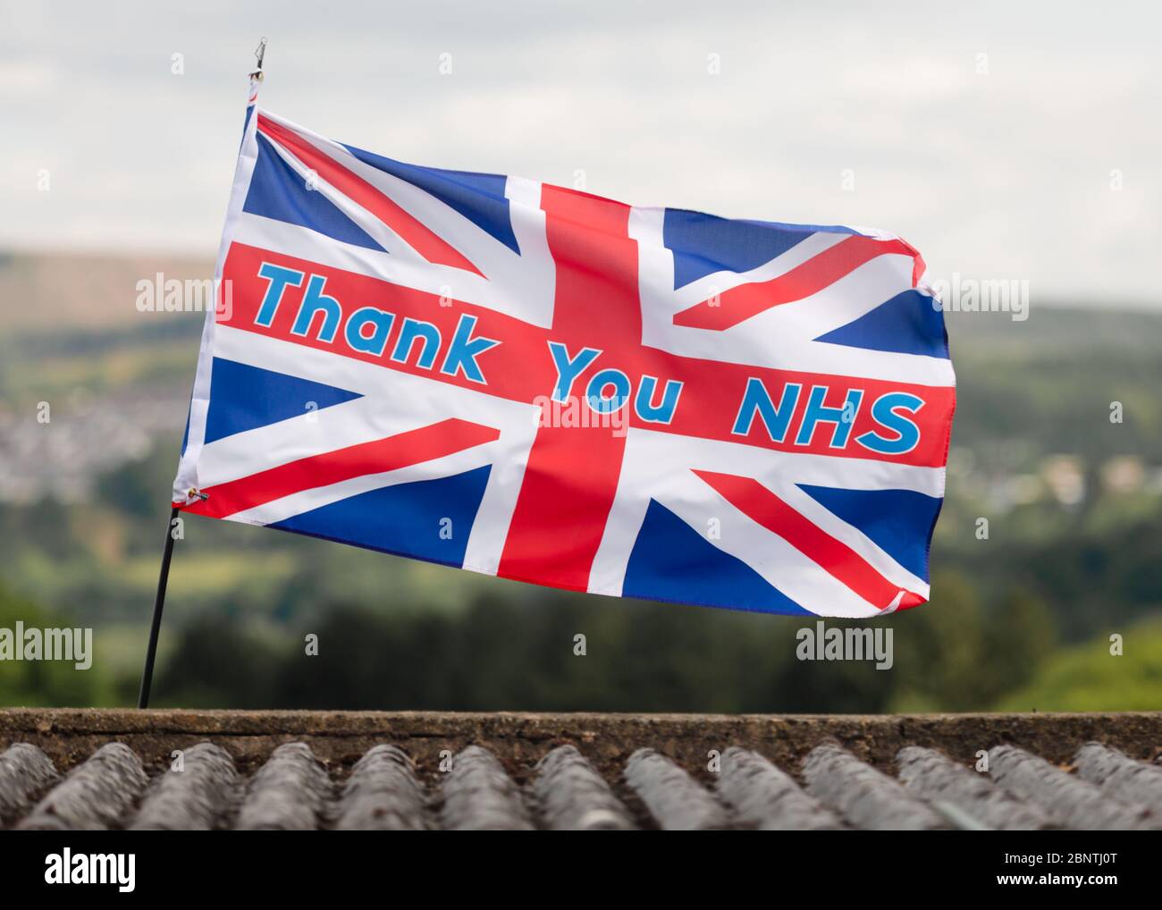 Newport, Galles, Regno Unito. 16 maggio 2020. Una bandiera di union jack con lo slogan grazie NHS, soffia nel vento sopra un tetto durante la pandemia di Coronavirus Covid-19 nel Regno Unito. Credit: Tracey Paddison/Alamy Live News Foto Stock