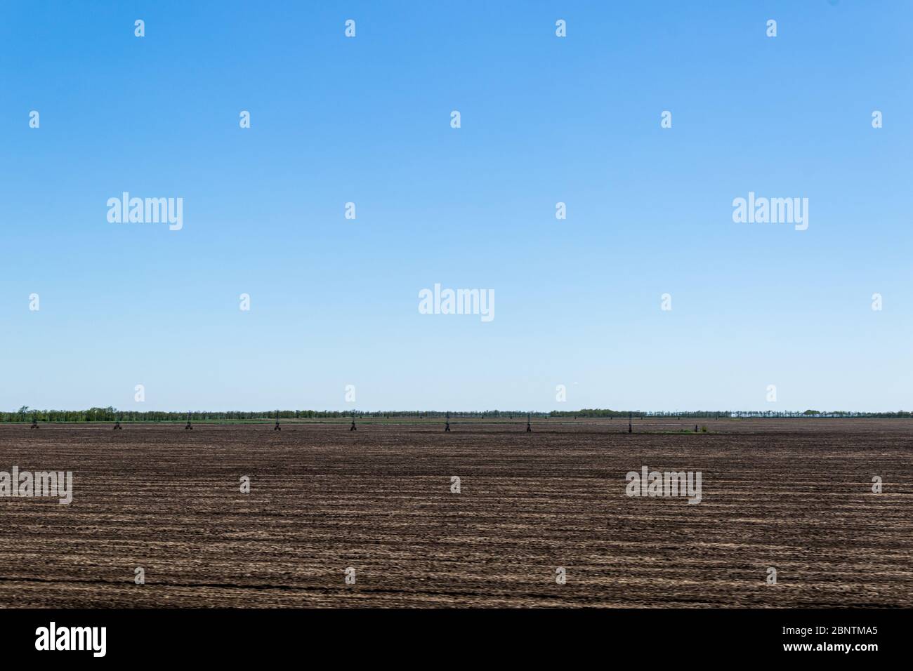 Sprinkler agricoli su un campo asciutto. Sistema di irrigazione in campo. Foto Stock