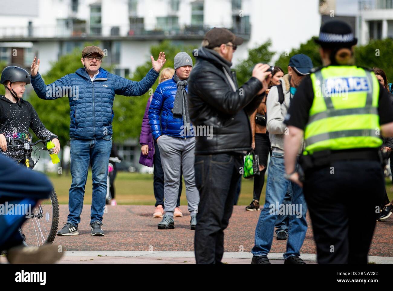 La polizia partecipa come membri del pubblico si riuniscono a Glasgow Green per protestare contro le restrizioni di blocco del coronavirus. Foto Stock