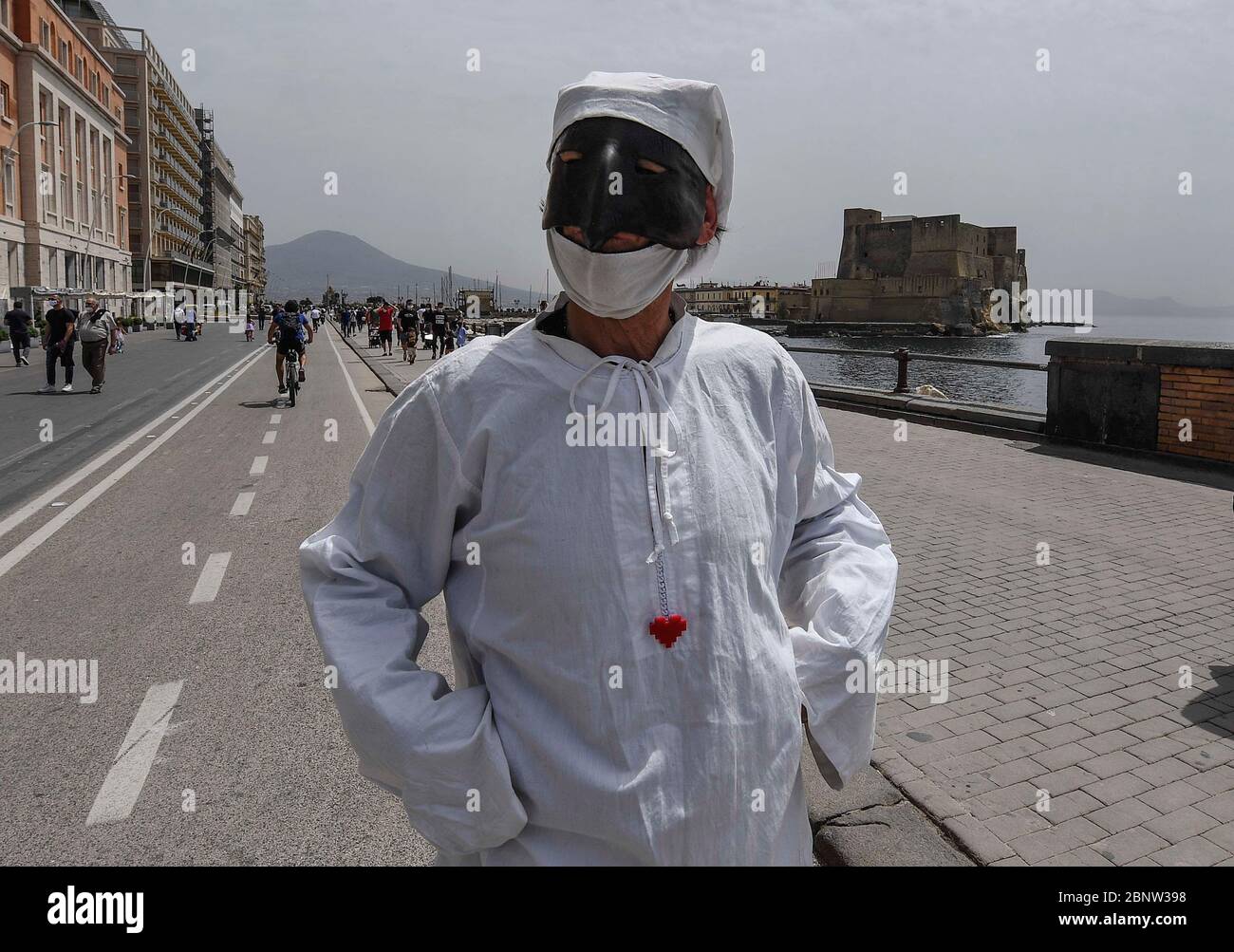 Un artista napoletano vestito da Punch (Pulcinella), maschera della  tradizione teatrale napoletana, si esibisce tra le persone sul lungomare di  Napoli. L'Italia comincia la fine di un blocco nazionale a causa della