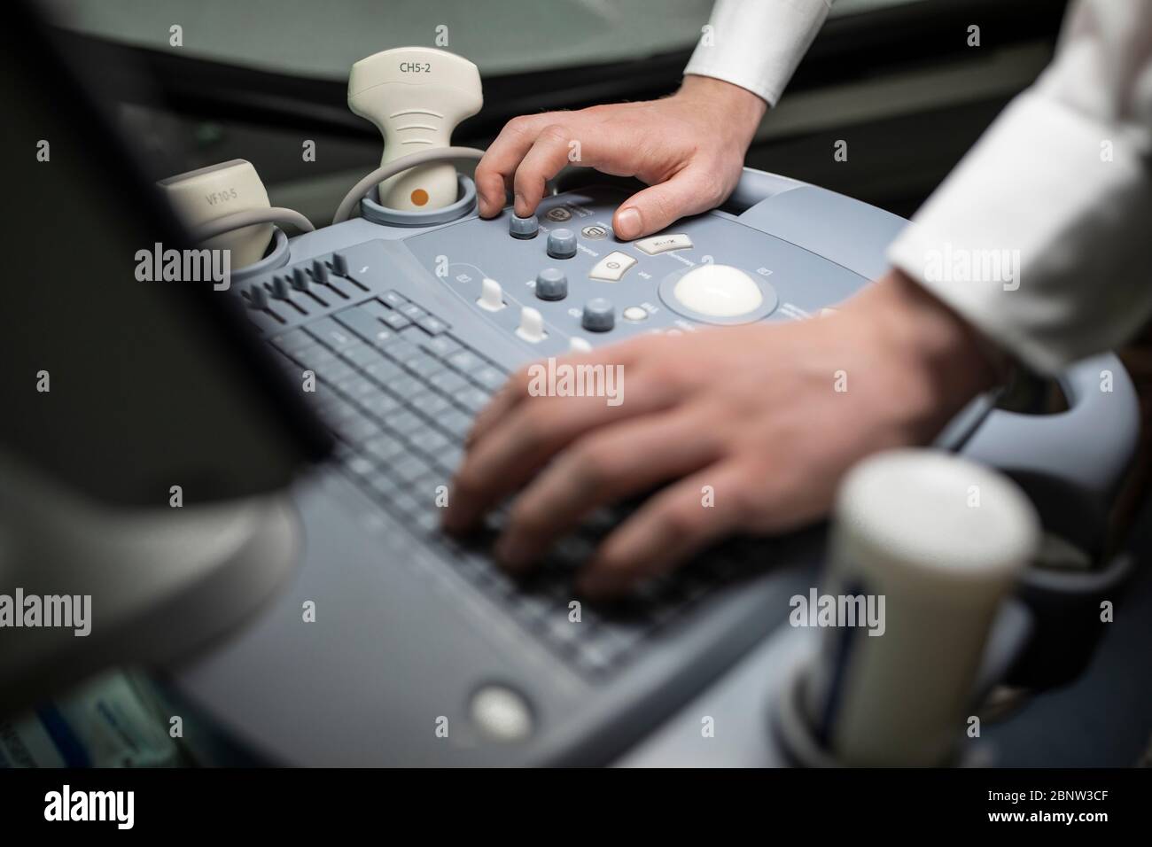 Primo piano del tecnico che utilizza una macchina a ultrasuoni in una clinica. Foto Stock