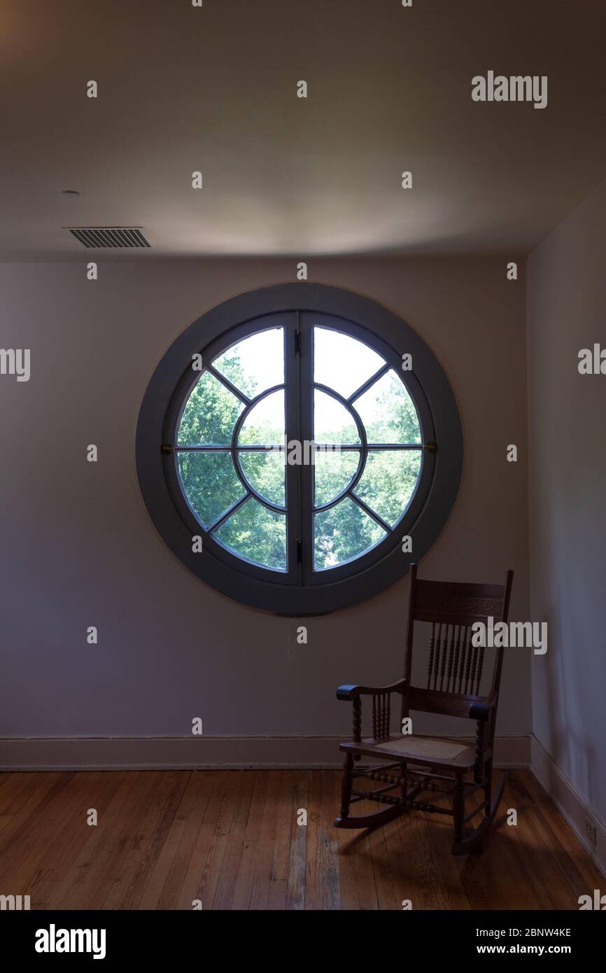 Grande finestra rotonda novel, camera poco illuminata con vecchia sedia a  dondolo, metafora per morte e solitudine, dolore, aspetto verticale Foto  stock - Alamy