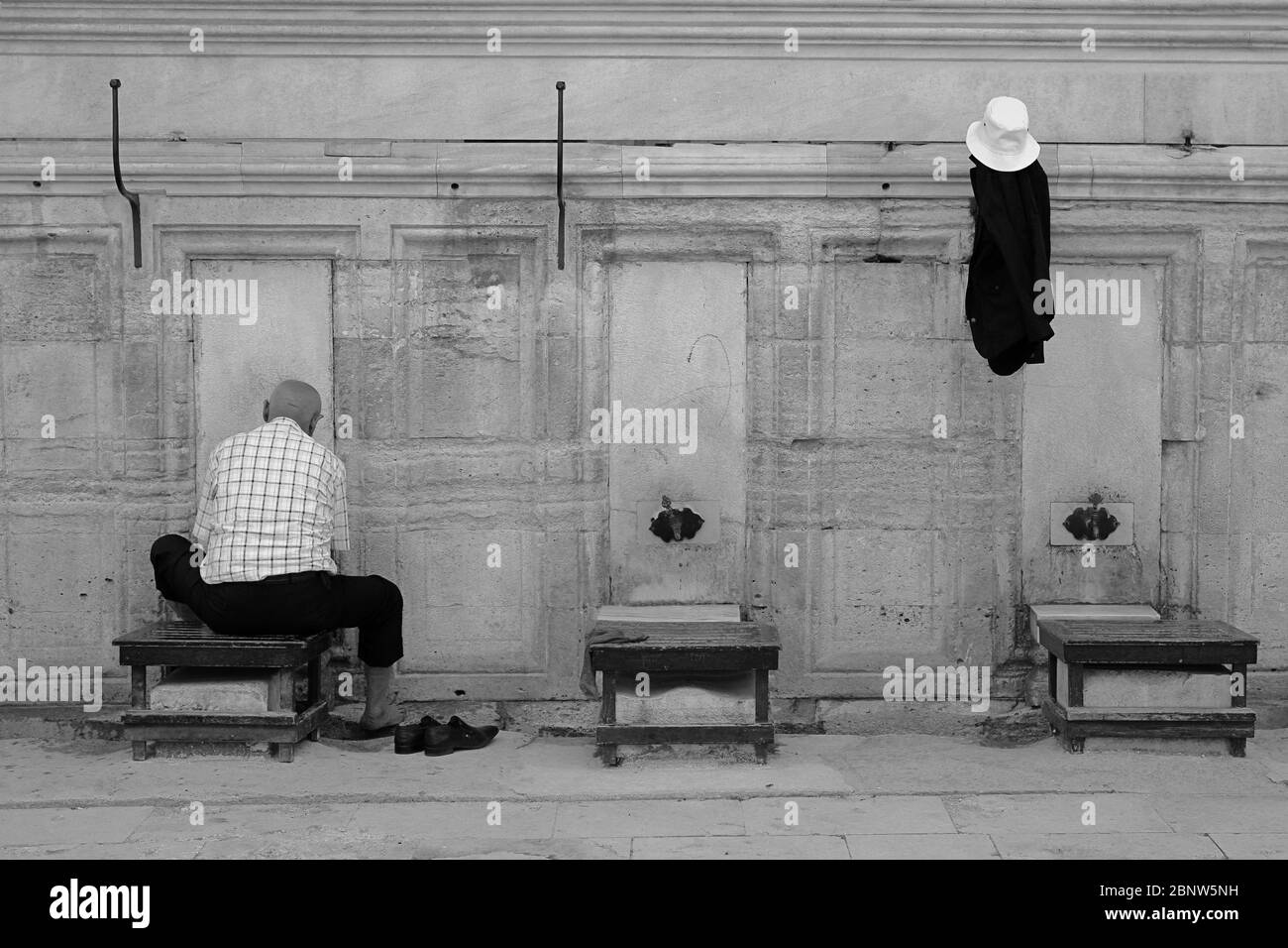 Uomo musulmano che si abluzioni nella moschea di Fatih. L'abluzione o il wudu è rituale islamico. Foto Stock