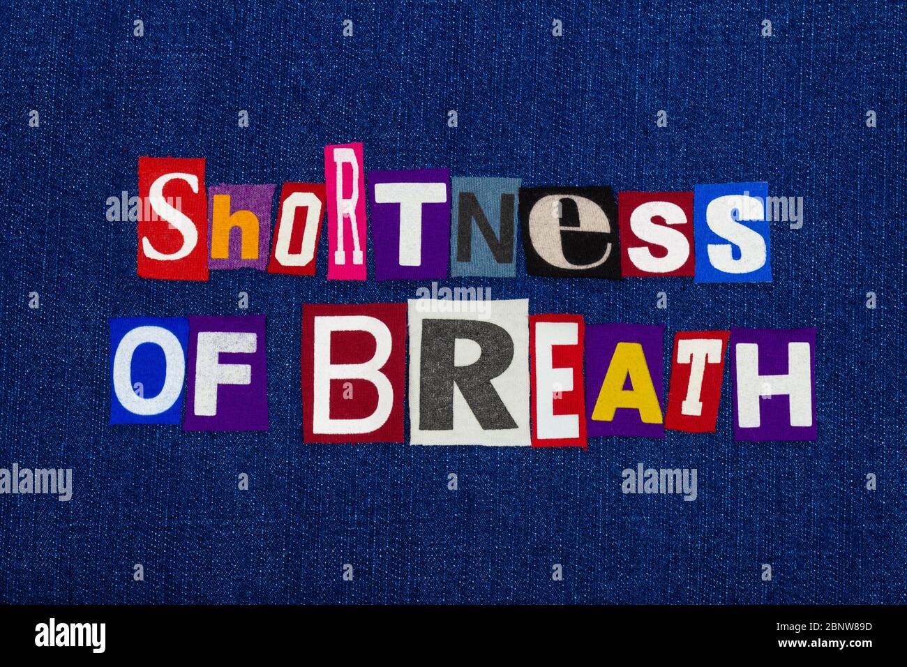 MANCANZA DI RESPIRO Coronavirus COVID-19 sintomo, collage parola di testo, pandemia mondiale virus influenza informazioni, lettere colorate su denim blu, orizzonte Foto Stock