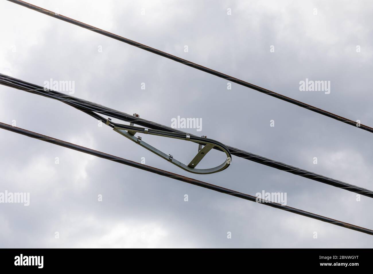 Racchette da neve in fibra ottica con linee elettriche contro un cielo grigio con nuvole pesanti, aspetto orizzontale Foto Stock