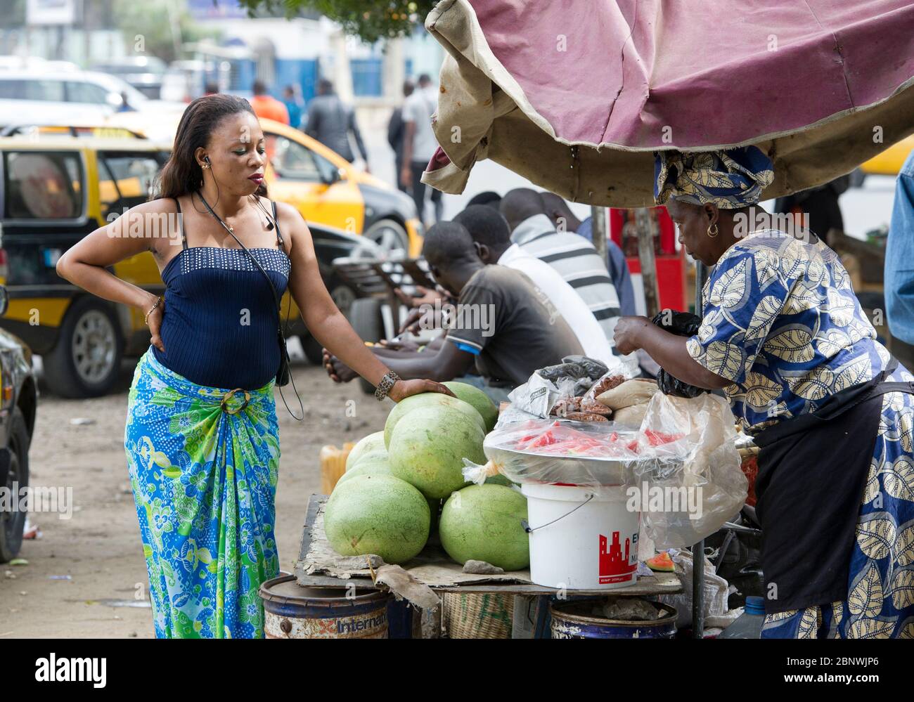 Una donna attende di essere servita in un mercato della frutta a Dakar, Senegal, Africa occidentale. Foto Stock