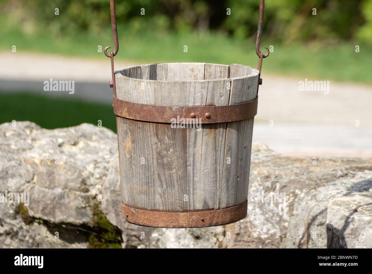 Primo piano di un vecchio secchio di legno antico appeso su un pozzo Foto  stock - Alamy