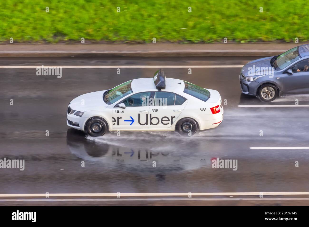 Auto bianca Uber Taxi giostra sulla vista aerea dell'autostrada. Russia, San Pietroburgo. 15 maggio 2020 Foto Stock