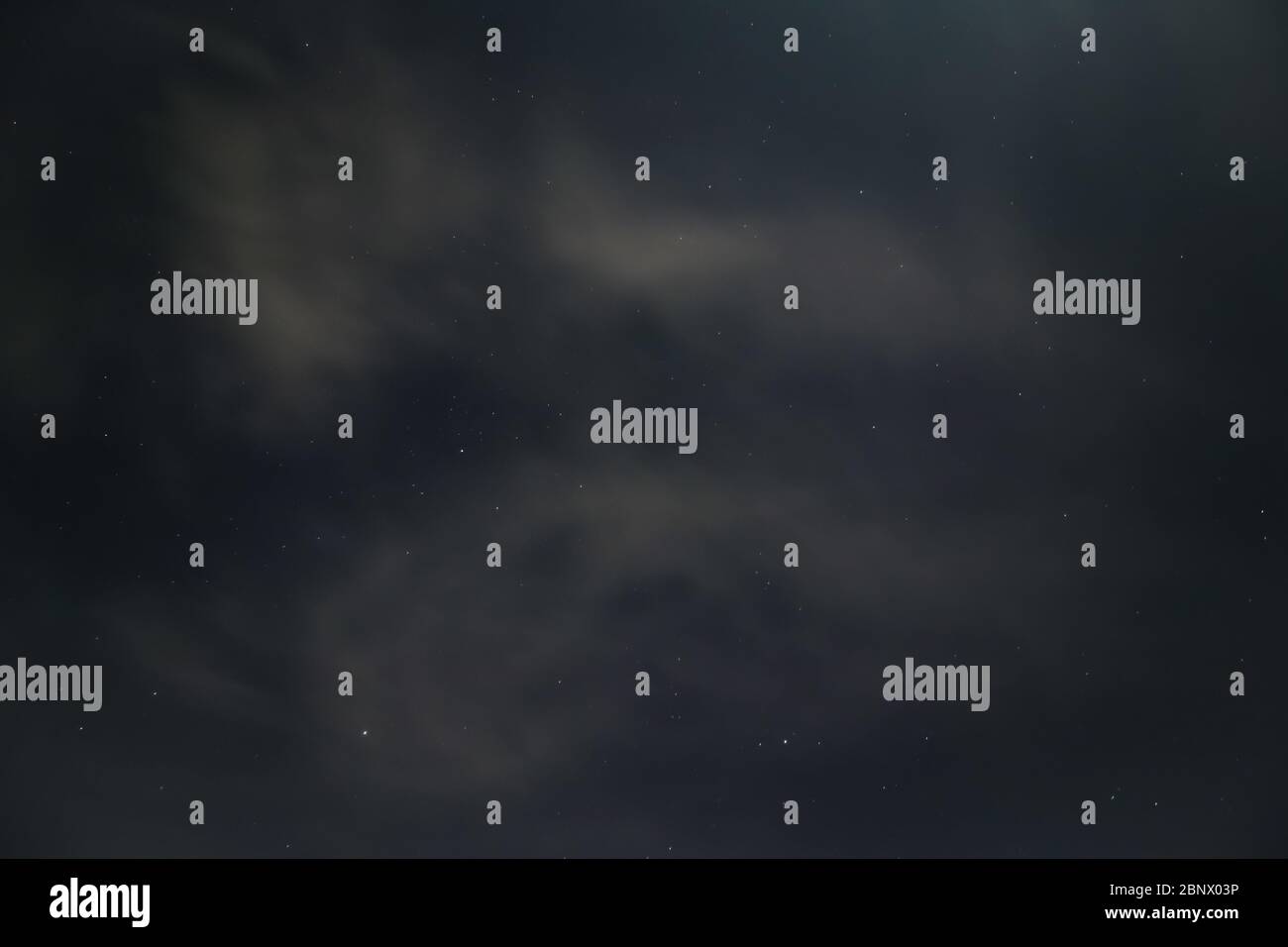 I colori veri del cielo notturno, che è coperto di nuvole con stelle che brillano sopra lo strato di nuvola, 5K Foto Stock
