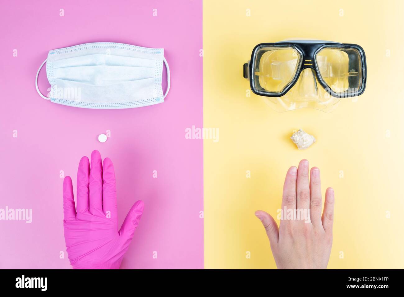 Concetto di visione 2020 per le vacanze estive. Mani femminili scegliendo tra una maschera medica e una maschera subacquea su un contrasto sfondo a due tonalità. Foto Stock