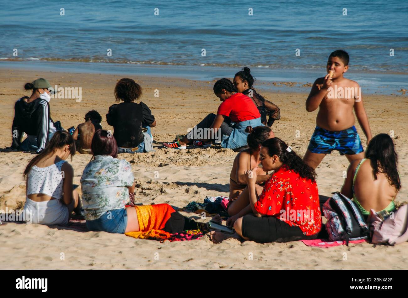 La gente si riunisce da vicino in una spiaggia a Cascais, Portogallo Foto Stock
