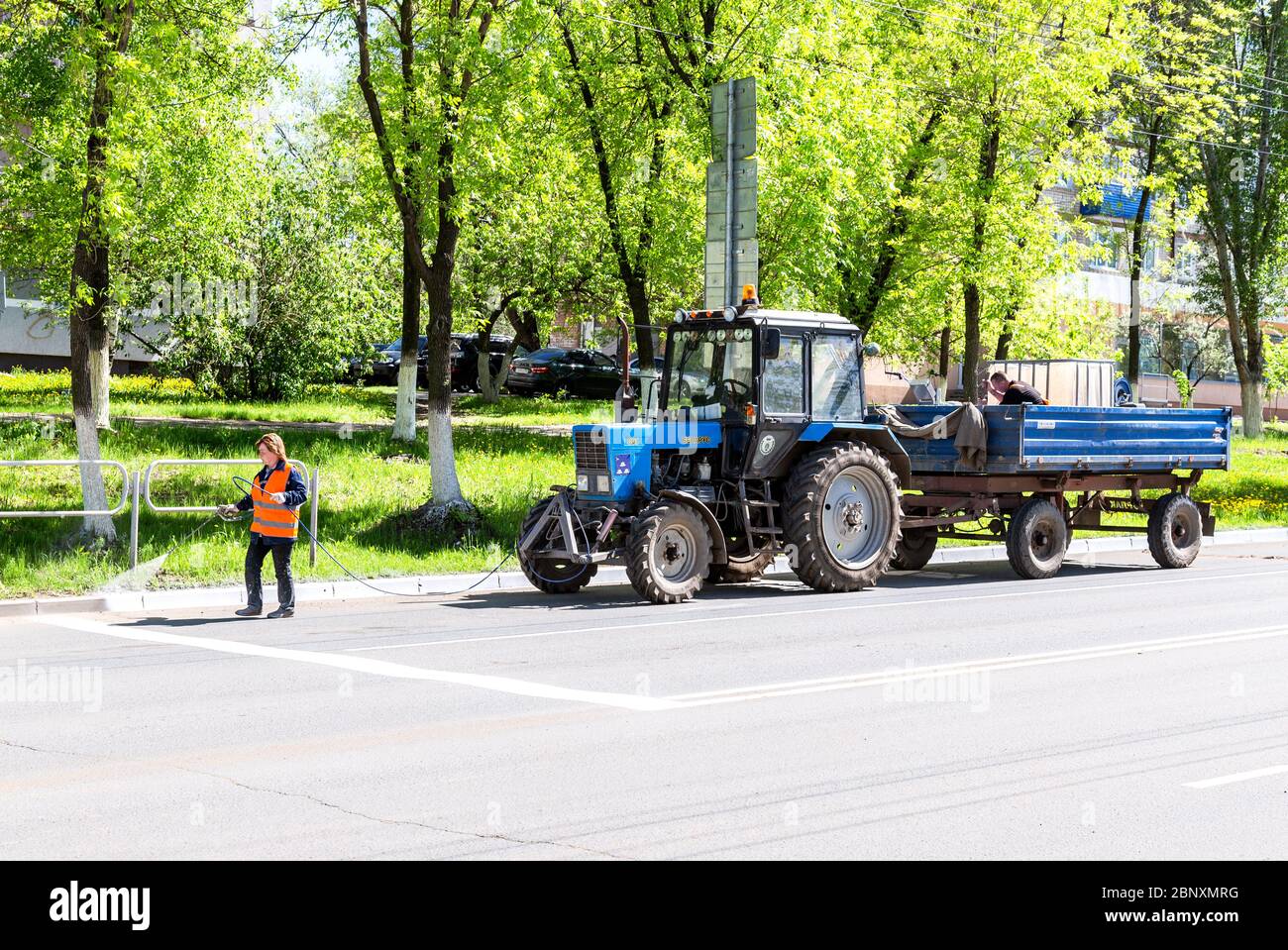 Samara, Russia - 14 maggio 2020: Lavori stradali per dipingere il cordolo recintato sulla strada asfaltata Foto Stock