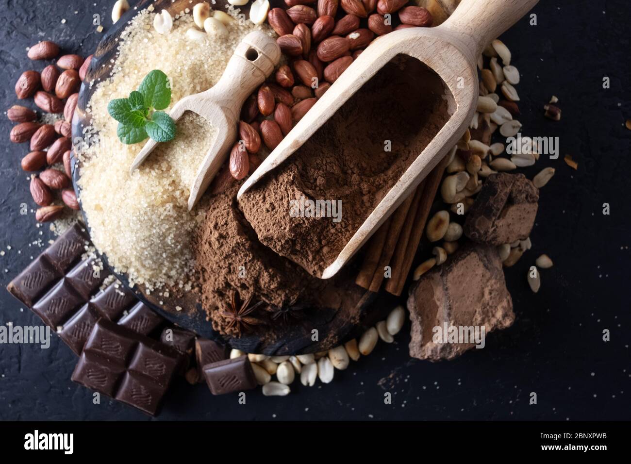 La polvere di cacao, cioccolato, noci e spezie su di un tavolo di legno. Fotografia di cibo Foto Stock