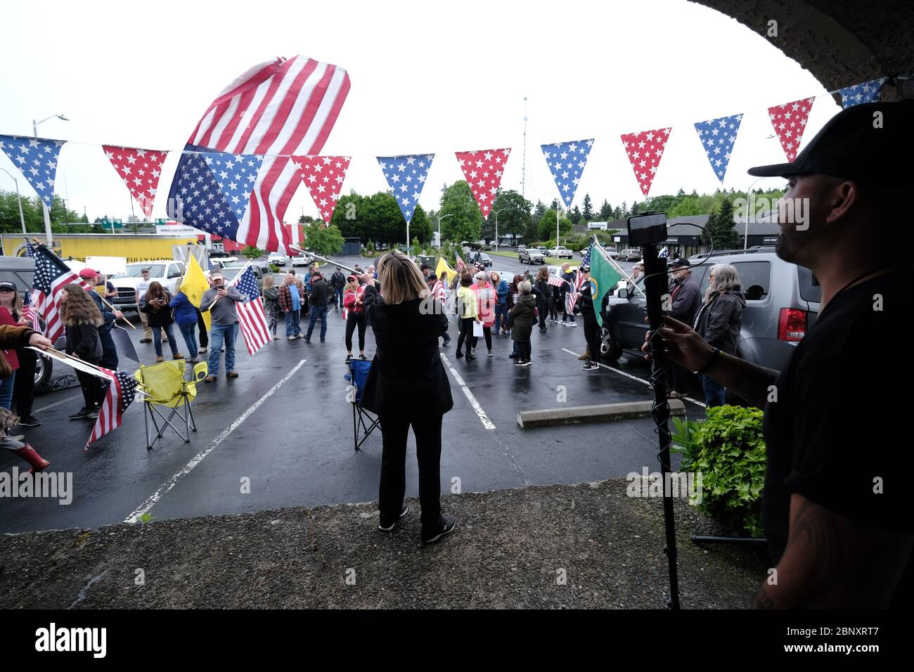 Vancouver, Stati Uniti. 16 maggio 2020. Il capo della preghiera del Patriot Joey Gibson filma Kelly Carroll che ha ufficialmente aperto la sua attività, il Biz del animale domestico, un'operazione di cura di lusso dell'animale domestico a Vancouver, Washington, il 16 maggio 2020. L'apertura è una violazione diretta degli ordini del governatore Jay Inslee di mantenere le attività non essenziali in questo momento chiuse, ma Kelly, che è già operativa da cinque giorni, insiste sulla necessità di aprire per sostenere le sue figlie. (Foto di Alex Milan Tracy/Sipa USA) Credit: Sipa USA/Alamy Live News Foto Stock