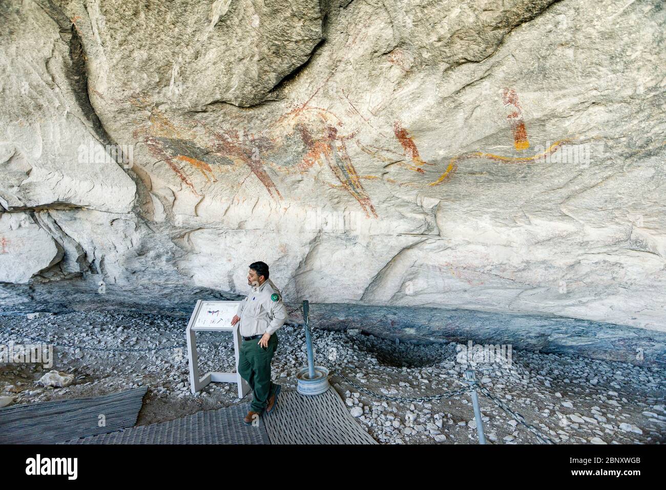 Guida turistica di fronte al pannello campanaria di fate Navajo Pictogra Foto Stock