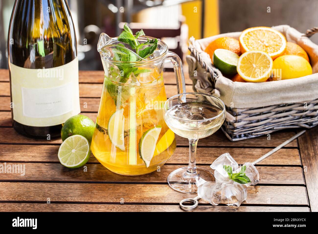 Bevanda estiva fresca con agrumi e ghiaccio. Foglie di arancio, lime, menta Foto Stock