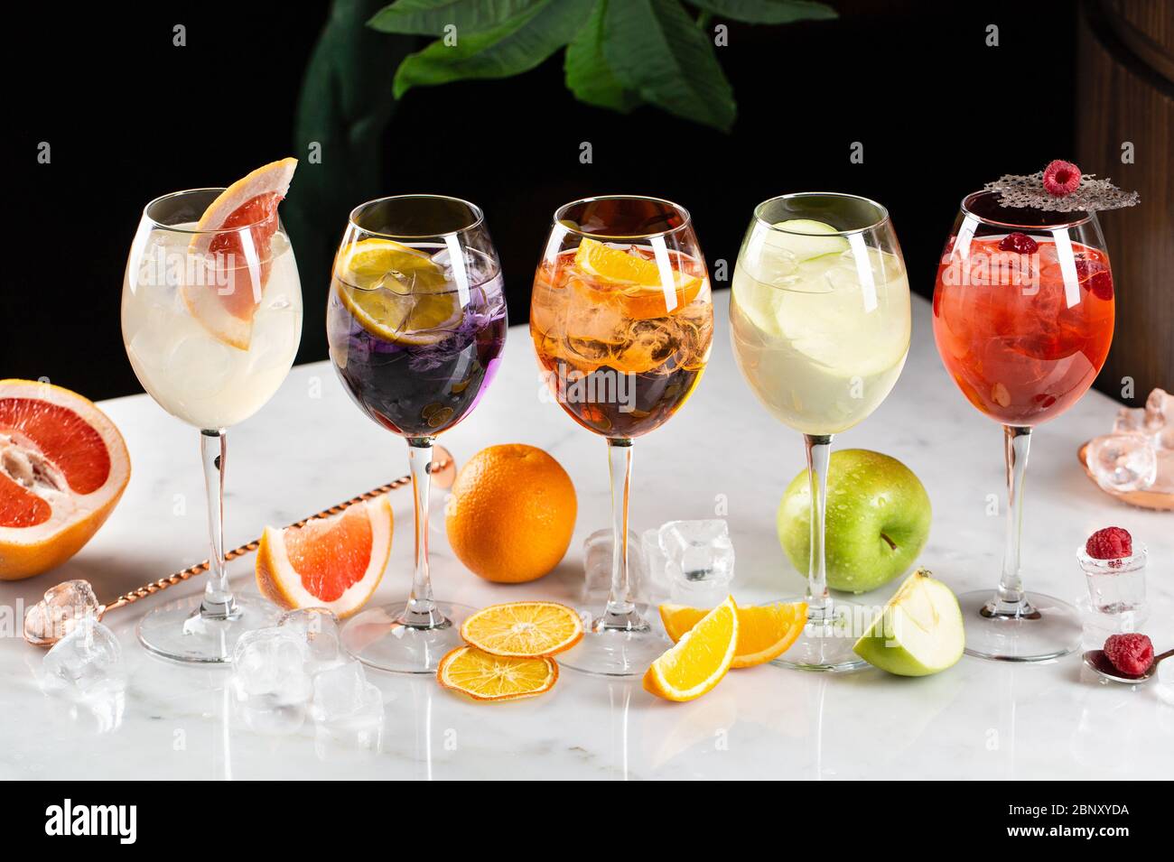 Cocktail alcolici e non alcolici con ghiaccio, frutta, bacche Foto Stock